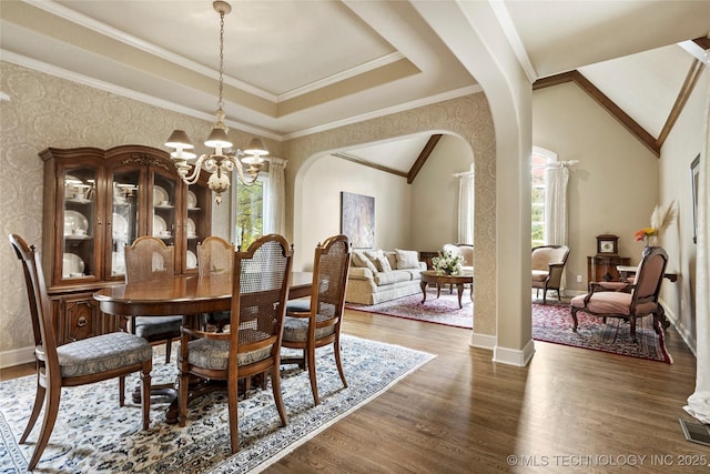 9632 S Vandalia Ave, Tulsa, OK 74137 - dining space with arched walkways, wood finished floors, a chandelier, and vaulted ceiling