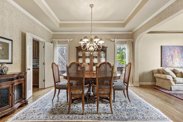 9632 S Vandalia Ave, Tulsa, OK 74137 - dining area with a tray ceiling, light wood-type flooring, a chandelier, crown molding, and arched walkways