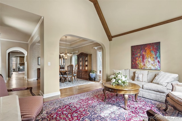 9632 S Vandalia Ave, Tulsa, OK 74137 - living room with arched walkways, wood finished floors, a chandelier, ornamental molding, and beam ceiling