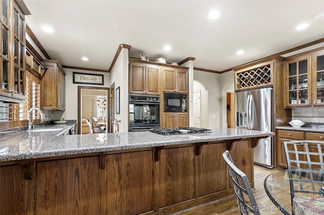 9632 S Vandalia Ave, Tulsa, OK 74137 - kitchen with appliances with stainless steel finishes, crown molding, light stone countertops, a peninsula, and recessed lighting