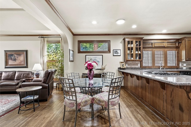 9632 S Vandalia Ave, Tulsa, OK 74137 - dining room featuring wood finished floors, ornamental molding, recessed lighting, and arched walkways