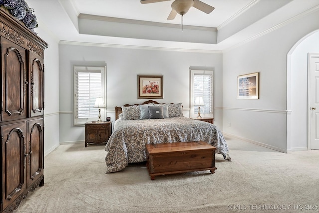 9632 S Vandalia Ave, Tulsa, OK 74137 - bedroom featuring light colored carpet, a tray ceiling, crown molding, arched walkways, and ceiling fan