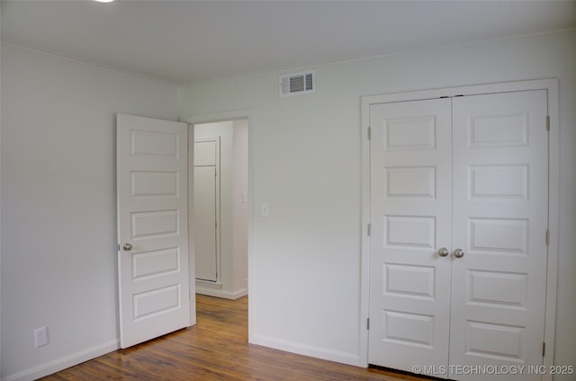 3634 S Pittsburg Ave, Tulsa, OK 74135 - unfurnished bedroom with dark wood-style floors, ornamental molding, and a closet