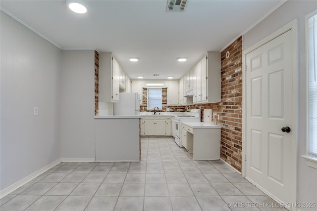 1417 Downing St, Oklahoma City, OK 73120 - kitchen with white appliances, light countertops, brick wall, white cabinets, and light tile patterned floors