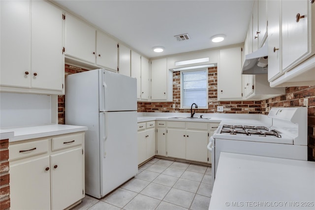 1417 Downing St, Oklahoma City, OK 73120 - kitchen with white appliances, under cabinet range hood, light countertops, and tasteful backsplash