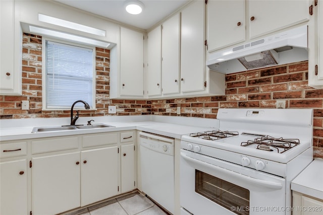 1417 Downing St, Oklahoma City, OK 73120 - kitchen with white appliances, under cabinet range hood, light countertops, light tile patterned floors, and brick wall