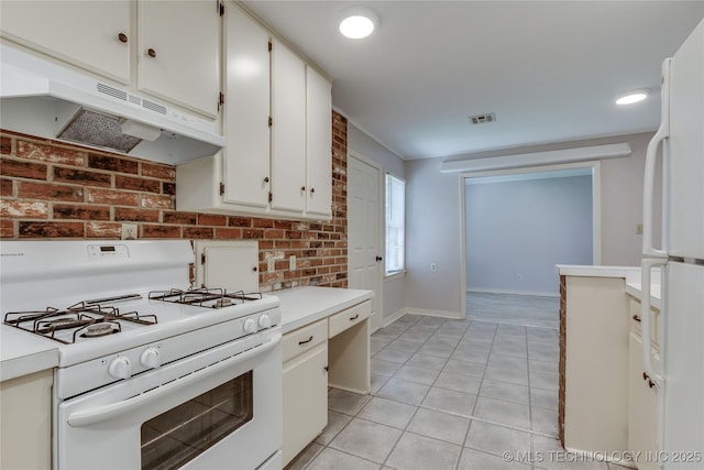 1417 Downing St, Oklahoma City, OK 73120 - kitchen featuring white appliances, under cabinet range hood, light tile patterned floors, white cabinets, and light countertops