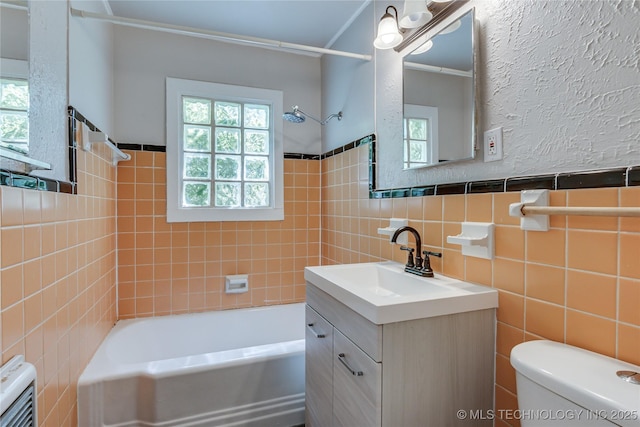 1417 Downing St, Oklahoma City, OK 73120 - full bath featuring tile walls, vanity, bathtub / shower combination, a wainscoted wall, and heating unit