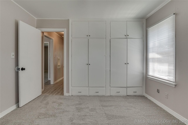 1417 Downing St, Oklahoma City, OK 73120 - unfurnished bedroom with light carpet, ornamental molding, and a closet
