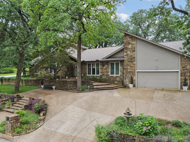 3334 E 100th Pl, Tulsa, OK 74137 - view of front of home featuring driveway, stone siding, and a shingled roof