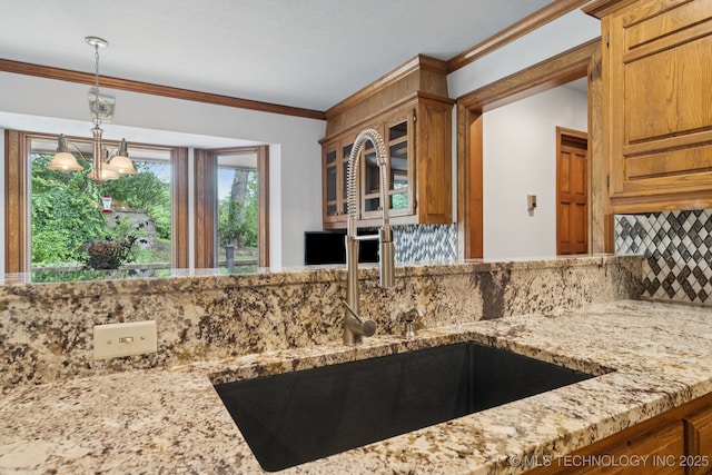 3334 E 100th Pl, Tulsa, OK 74137 - kitchen with light stone counters, backsplash, a chandelier, crown molding, and pendant lighting