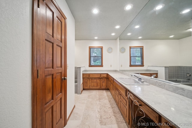3334 E 100th Pl, Tulsa, OK 74137 - kitchen featuring recessed lighting, brown cabinetry, and light stone countertops