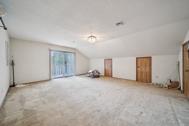 3334 E 100th Pl, Tulsa, OK 74137 - additional living space featuring vaulted ceiling, a textured ceiling, and carpet floors