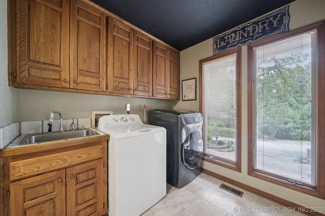 3334 E 100th Pl, Tulsa, OK 74137 - washroom with cabinet space, washer and clothes dryer, and plenty of natural light
