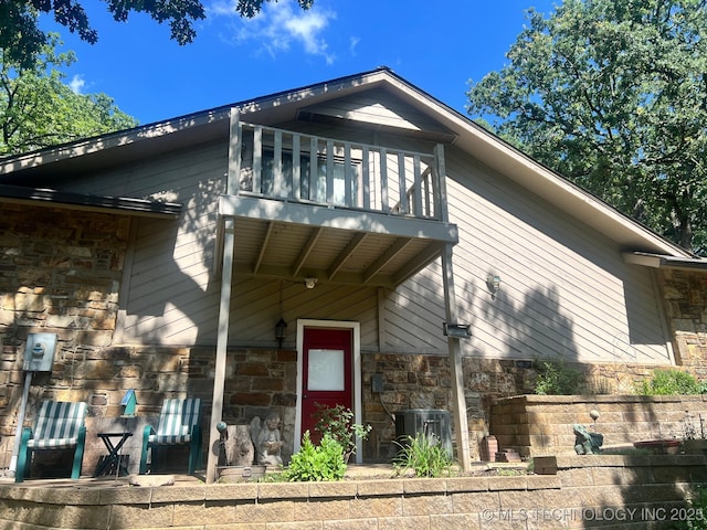 3334 E 100th Pl, Tulsa, OK 74137 - view of front of house with stone siding and a balcony