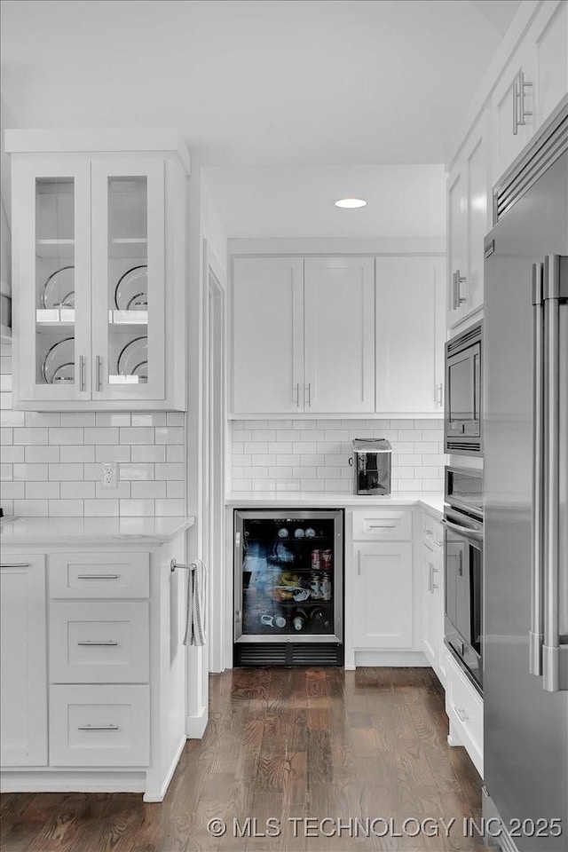 7107 E 88th St N, Owasso, OK 74055 - kitchen with built in appliances, wine cooler, light countertops, backsplash, and white cabinetry