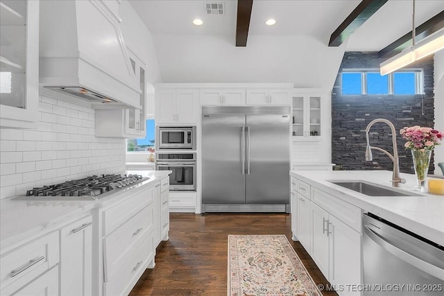 7107 E 88th St N, Owasso, OK 74055 - kitchen featuring built in appliances, custom range hood, decorative backsplash, white cabinetry, and beam ceiling