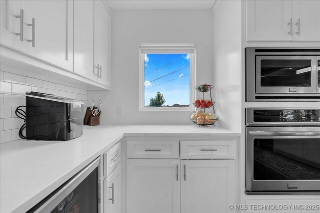 7107 E 88th St N, Owasso, OK 74055 - kitchen with stainless steel appliances and white cabinetry