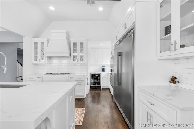 7107 E 88th St N, Owasso, OK 74055 - kitchen featuring stainless steel appliances, wine cooler, premium range hood, decorative backsplash, and lofted ceiling