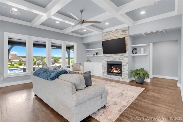 7107 E 88th St N, Owasso, OK 74055 - living area featuring coffered ceiling, ceiling fan, a stone fireplace, built in features, and dark wood finished floors