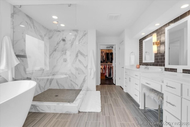7107 E 88th St N, Owasso, OK 74055 - bathroom featuring a freestanding bath, a marble finish shower, vanity, tile walls, and recessed lighting
