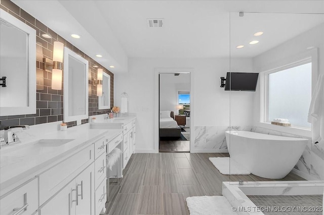 7107 E 88th St N, Owasso, OK 74055 - full bath with a soaking tub, double vanity, recessed lighting, tile walls, and connected bathroom