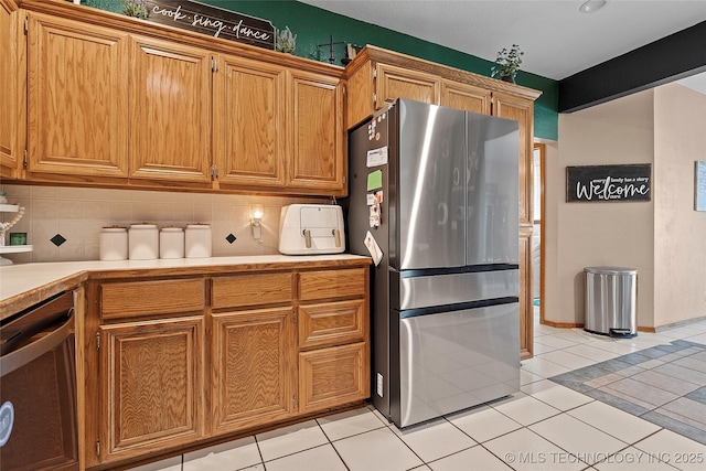 1507 Southern Hills Dr, Ardmore, OK 73401 - kitchen featuring appliances with stainless steel finishes, light countertops, tasteful backsplash, light tile patterned flooring, and brown cabinets