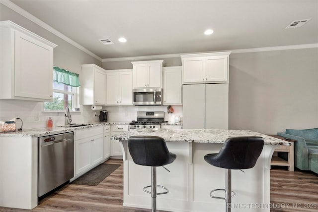 26806 E 143rd St S, Coweta, OK 74429 - kitchen with stainless steel appliances, white cabinetry, crown molding, a breakfast bar, and recessed lighting