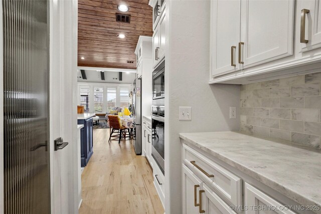 5314 E 126th St S, Bixby, OK 74008 - kitchen with appliances with stainless steel finishes, wooden ceiling, white cabinets, decorative backsplash, and light wood-style flooring