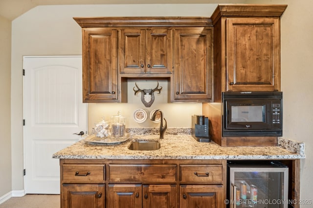 9545 E 108th St S, Bixby, OK 74133 - kitchen featuring beverage cooler, black microwave, light stone countertops, vaulted ceiling, and brown cabinetry