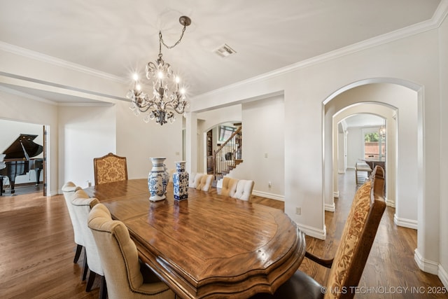 9545 E 108th St S, Bixby, OK 74133 - dining space with a chandelier, arched walkways, wood finished floors, ornamental molding, and stairway