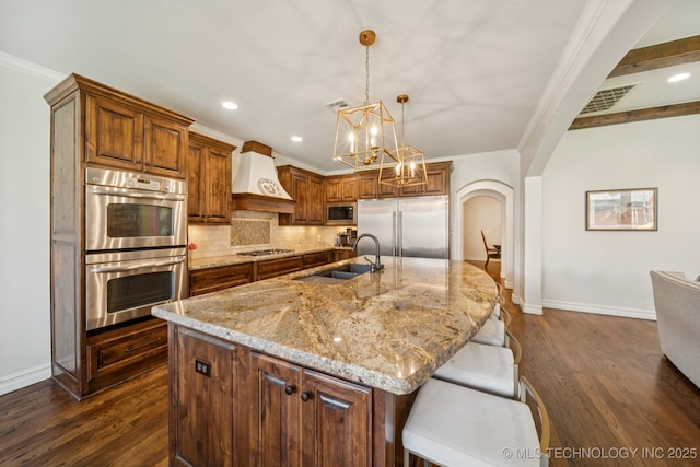 9545 E 108th St S, Bixby, OK 74133 - kitchen featuring built in appliances, custom exhaust hood, crown molding, dark wood-style floors, and decorative backsplash