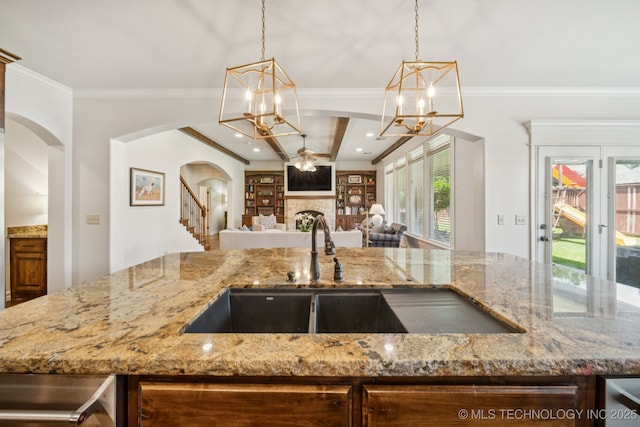 9545 E 108th St S, Bixby, OK 74133 - kitchen featuring a chandelier, open floor plan, arched walkways, a fireplace, and light stone counters