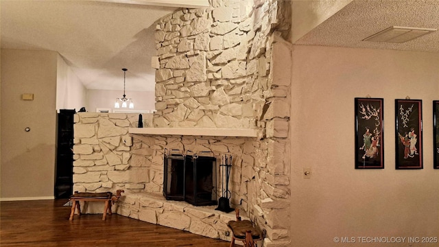4224 E 84th St, Tulsa, OK 74137 - unfurnished living room with wood finished floors, a textured ceiling, a chandelier, and a stone fireplace