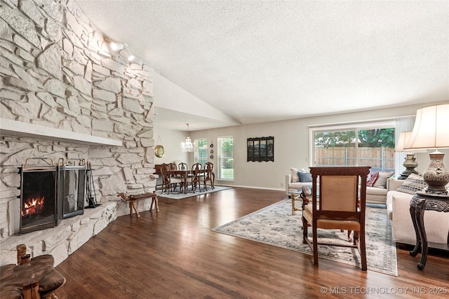 4224 E 84th St, Tulsa, OK 74137 - living room with a textured ceiling, wood finished floors, healthy amount of natural light, a stone fireplace, and a chandelier