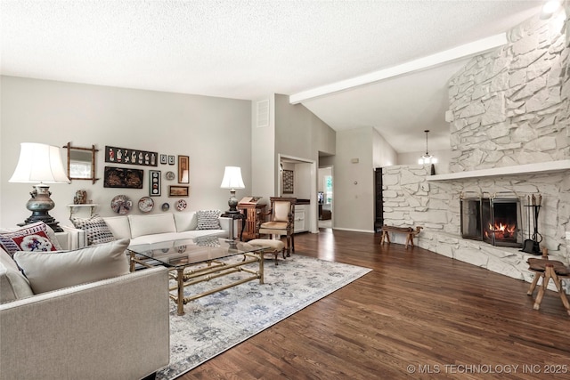 4224 E 84th St, Tulsa, OK 74137 - living room with wood finished floors, a stone fireplace, a chandelier, and a textured ceiling