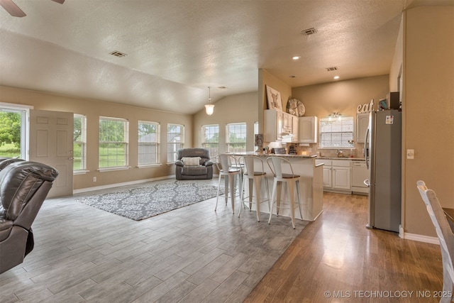 420 W 54th St, Sand Springs, OK 74063 - kitchen featuring open floor plan, freestanding refrigerator, plenty of natural light, light wood-style floors, and lofted ceiling
