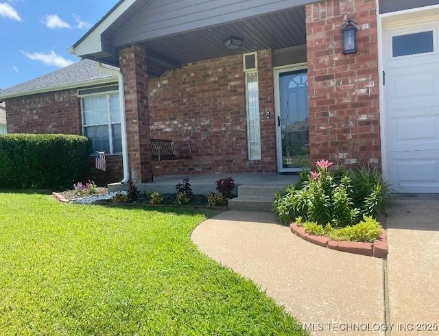 420 W 54th St, Sand Springs, OK 74063 - view of exterior entry featuring a porch, a yard, and brick siding