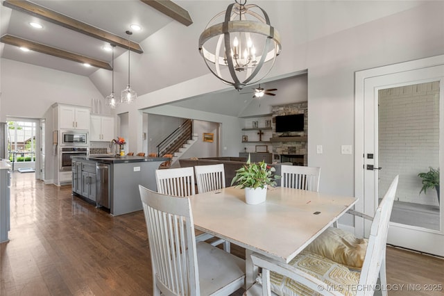 10470 E 123rd Pl S, Bixby, OK 74008 - dining room with high vaulted ceiling, dark wood-style flooring, a fireplace, a chandelier, and stairway