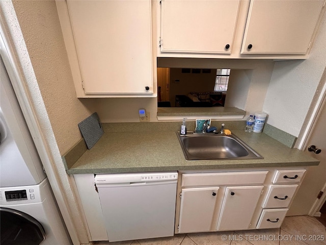 3402 S Winston Ave Unit 103, Tulsa, OK 74135 - kitchen featuring dishwasher, a textured wall, white cabinetry, stacked washing machine and dryer, and light countertops