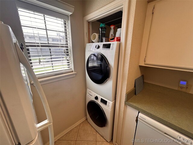 3402 S Winston Ave Unit 103, Tulsa, OK 74135 - laundry area featuring estacked washer and dryer, light tile patterned flooring, and healthy amount of natural light