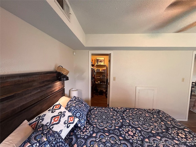 3402 S Winston Ave Unit 103, Tulsa, OK 74135 - bedroom featuring a textured ceiling and a walk in closet