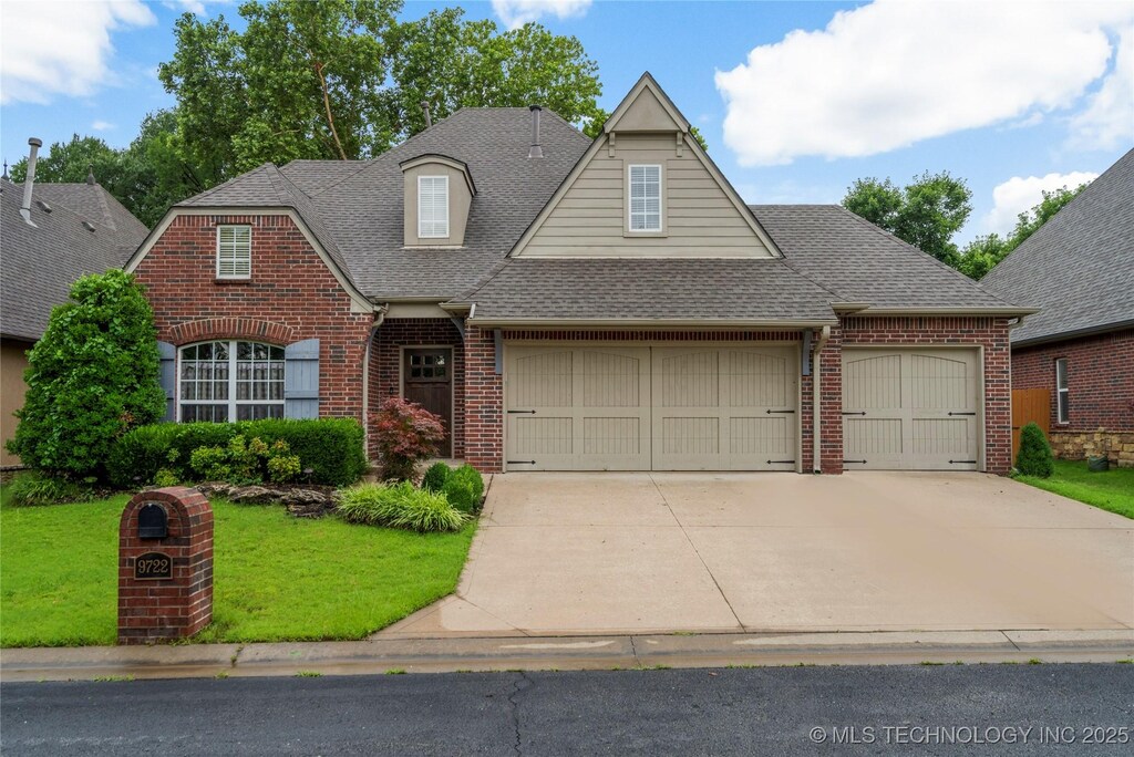 9722 S 75th E Ave, Tulsa, OK 74133 - view of front facade featuring brick siding, a garage, roof with shingles, a front yard, and driveway