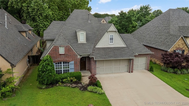 9722 S 75th E Ave, Tulsa, OK 74133 - view of front of home featuring brick siding, roof with shingles, an attached garage, and concrete driveway