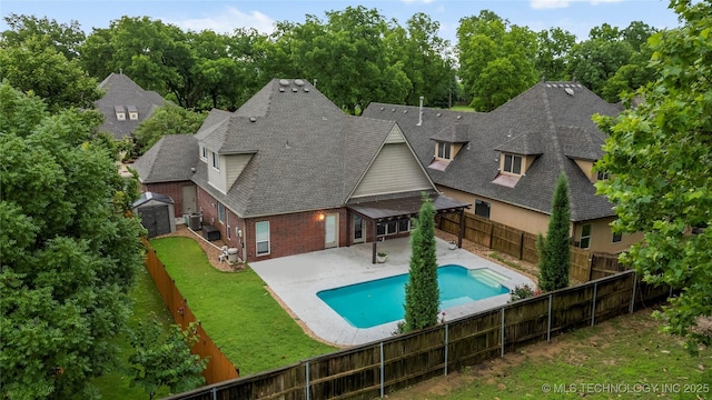 9722 S 75th E Ave, Tulsa, OK 74133 - view of swimming pool featuring a patio area, a fenced backyard, a storage unit, and view of wooded area