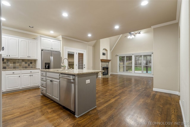 9722 S 75th E Ave, Tulsa, OK 74133 - kitchen featuring appliances with stainless steel finishes, open floor plan, crown molding, an island with sink, and white cabinets