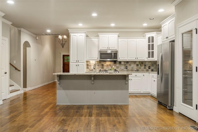 9722 S 75th E Ave, Tulsa, OK 74133 - kitchen featuring stainless steel appliances, decorative backsplash, light stone countertops, white cabinets, and ornamental molding