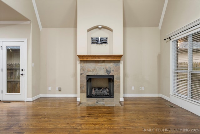 9722 S 75th E Ave, Tulsa, OK 74133 - unfurnished living room featuring wood finished floors, a tiled fireplace, and crown molding