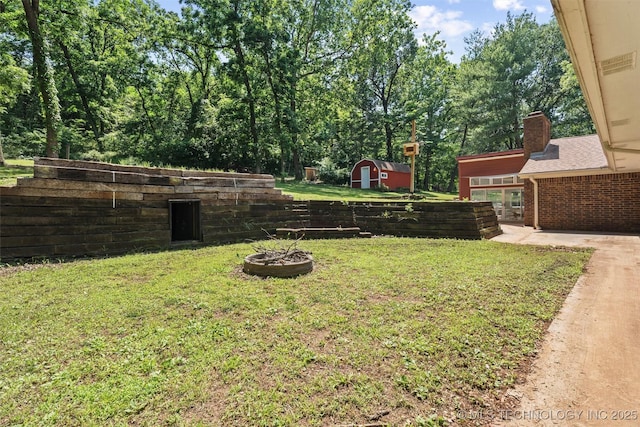 302 Southern Hills Dr, Coffeyville, KS 67337 - view of green lawn featuring a storage shed and a fire pit