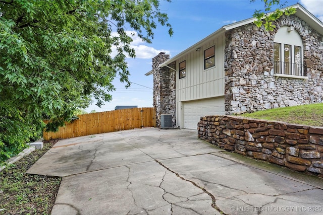 2936 E 75th St, Tulsa, OK 74136 - view of property exterior with stone siding, an attached garage, and a chimney
